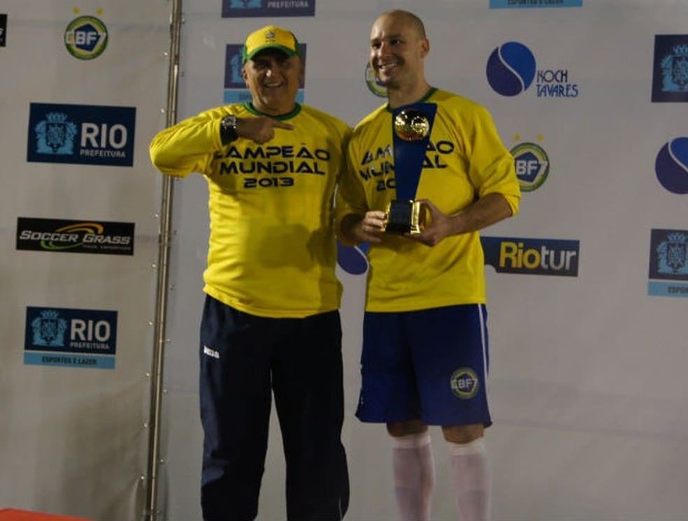 Rogério Corrêa com o troféu de melhor do mundo ao lado do técnico José Moraes — Foto: Flávio Dilascio