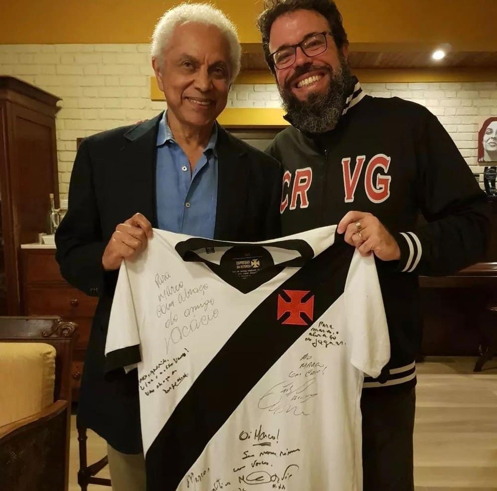 O cantor Paulinho da Viola e Marco Antonio Rocha, diretor de 'A força do Gigante', posam com uma camisa do Vasco autografada por todos os entrevistados no documentário — Foto: Divulgação